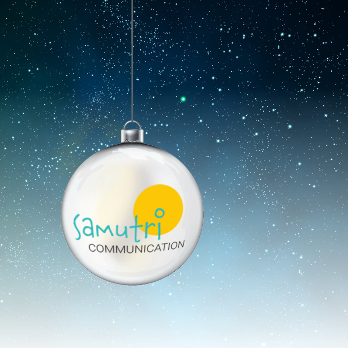 Weiße Weihnachtsbaumkugel mit Logo von samutri communication vor Sternenhimmel